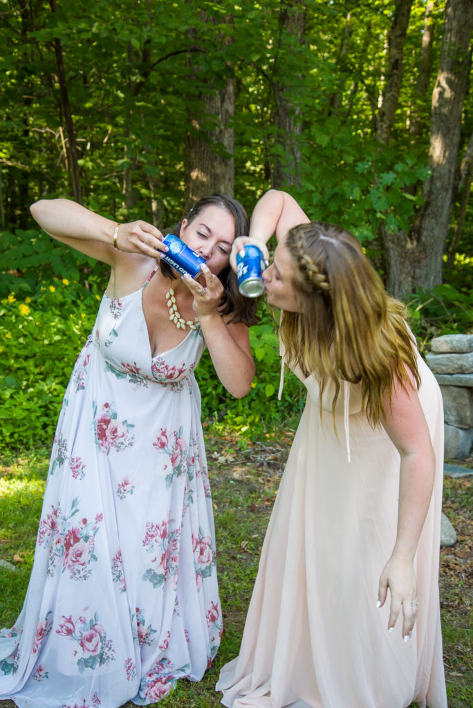 bride and maid of honor shot gunning a beer