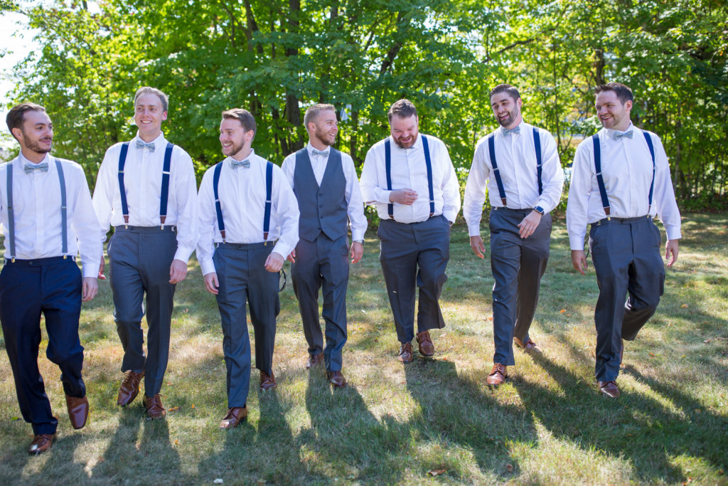 groom and his groomsmen walking and smiling at each other