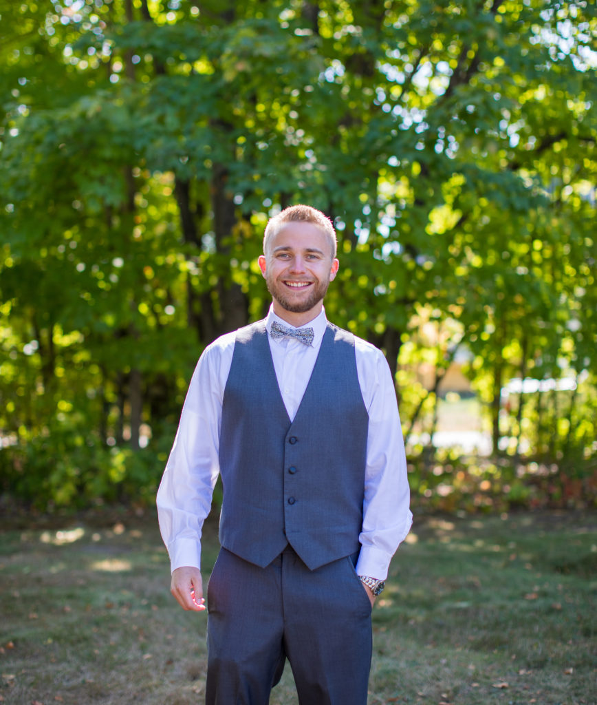 groom smiling at the camera outside in NH fall wedding