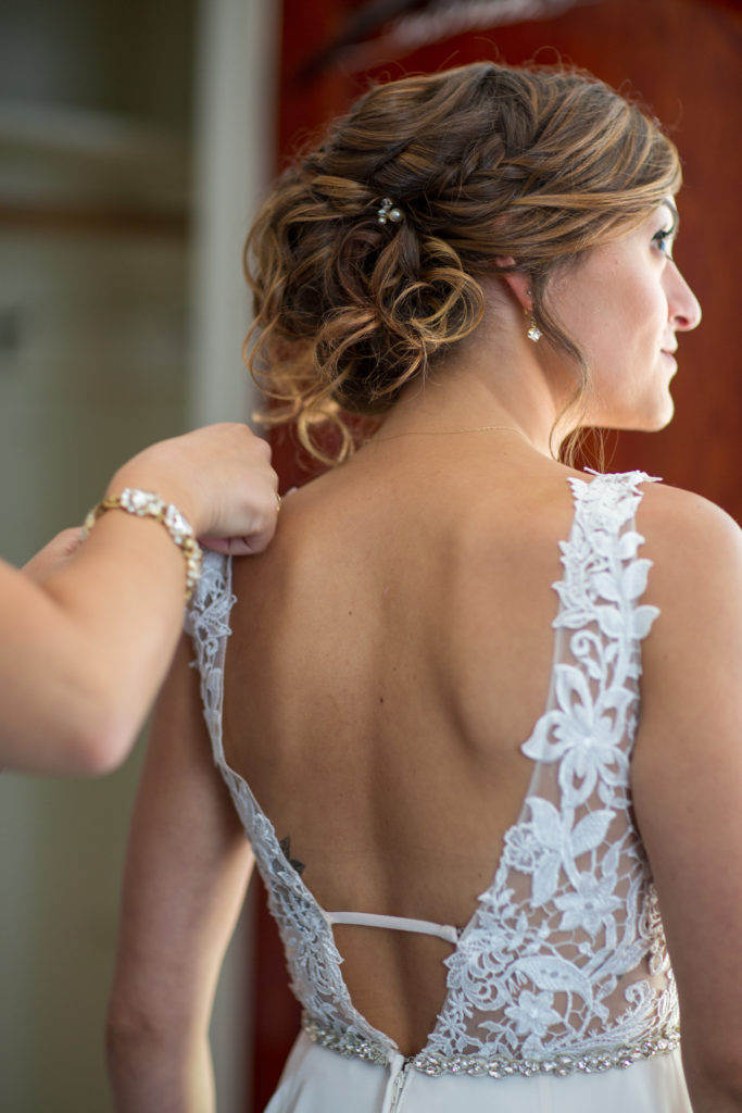 bride facing the window as her mom fixes her dress