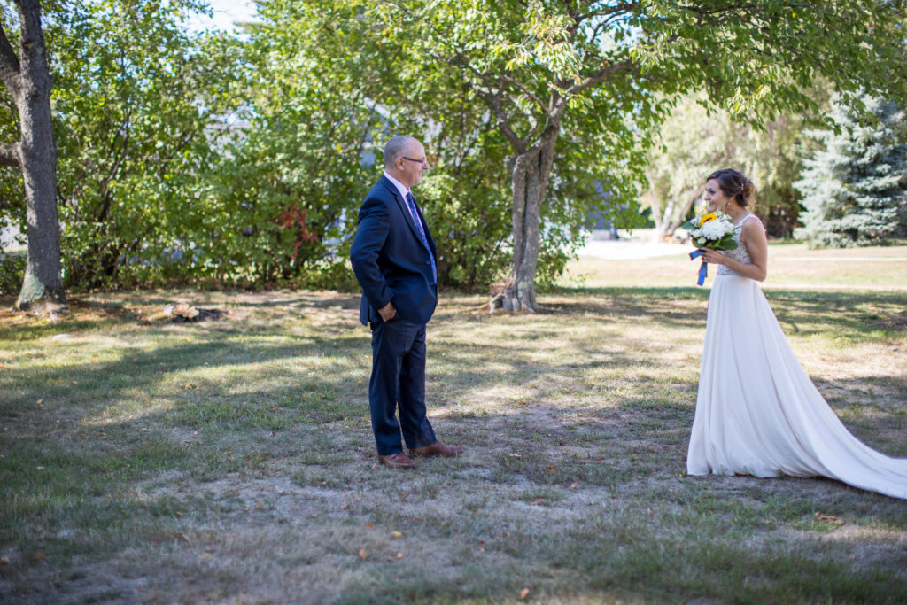 bride doing a first look with her father in the back yard