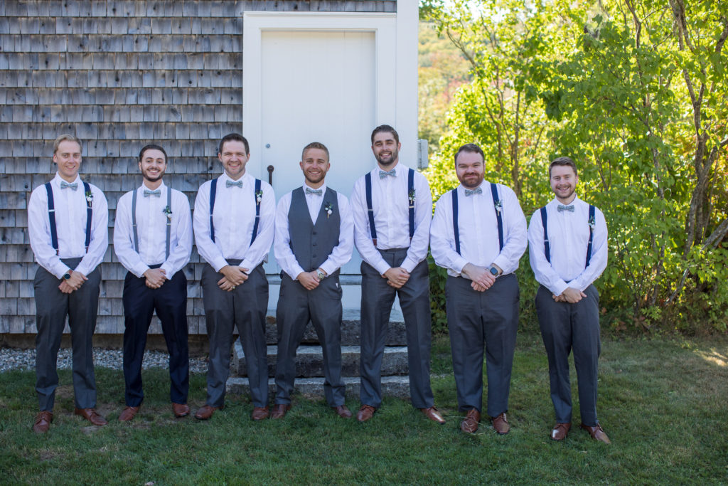 groom with his groomsmen, standing in a line and hands in front