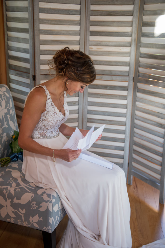 bride reading a letter from her husband to be before the ceremony