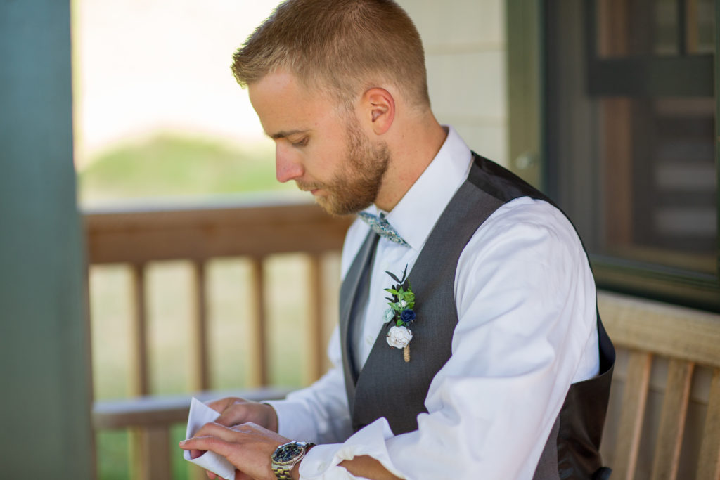 groom reading a letter from his wife to be before the ceremony