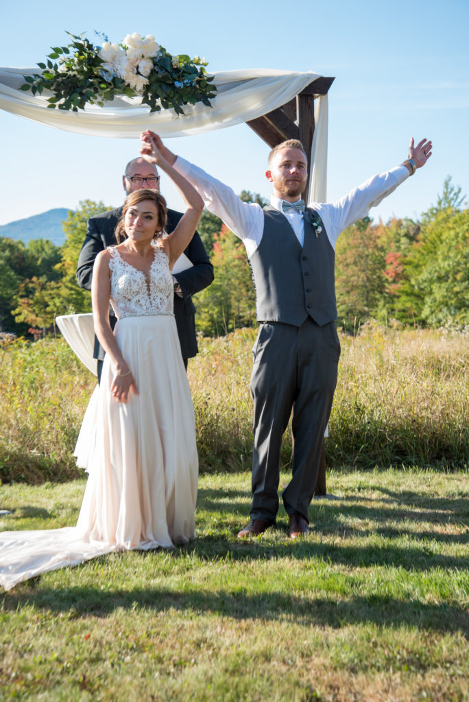 groom with his hands up in the air after ceremony as if to say "we did it!" 