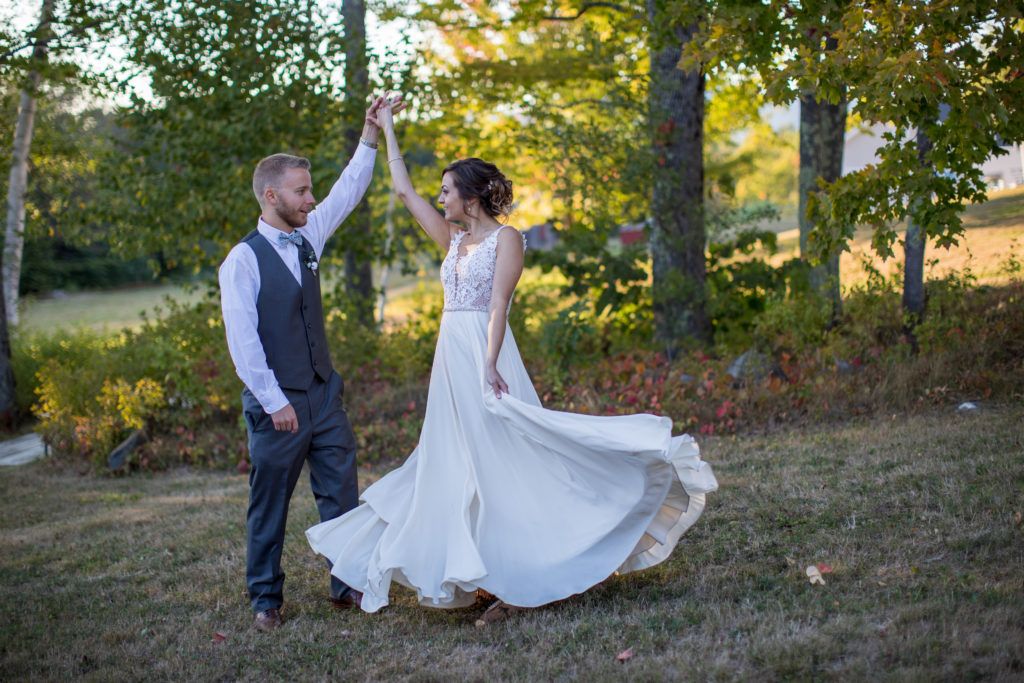 groom twirling bride in a field 
