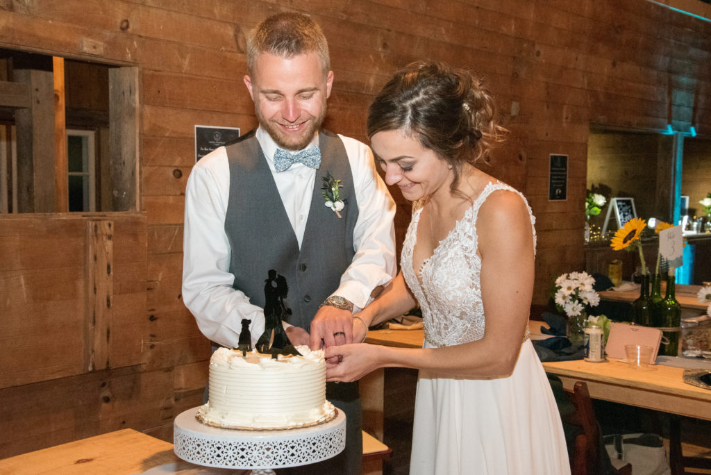 husband and wife cutting the cake at Barn at Moody Mountain Farm Wedding