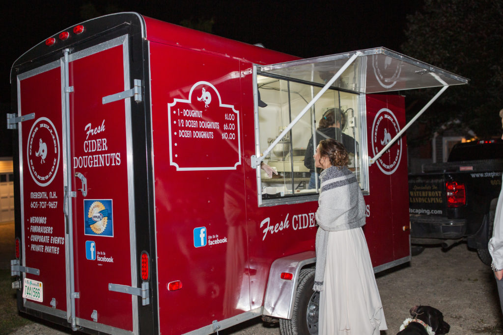 bride getting her donut from the donut food truck at her wedding 