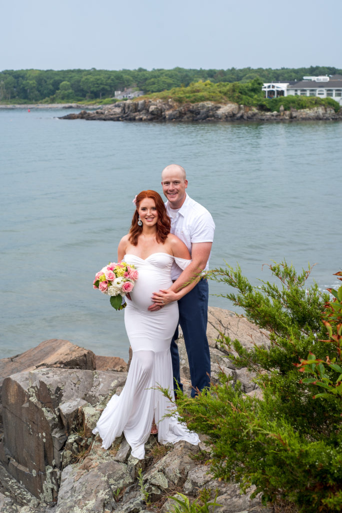 bride and groom standing on the rocks by the ocean at york harbor elopement 