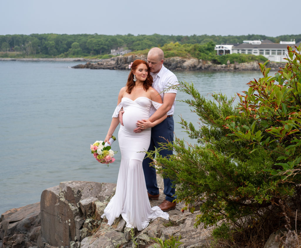 bride and groom standing on the rocks in front of the ocean at York Harbor Inn Elopement 