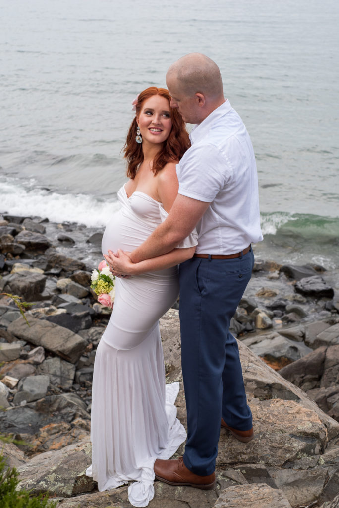 bride and groom smiling at each other on rocks in front of the ocean at York Harbor Inn elopement 