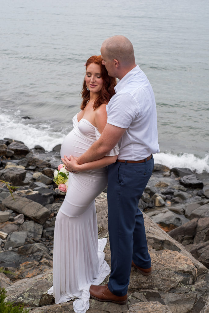 bride and groom standing on the rocks in front of the ocean at York Harbor Inn elopement