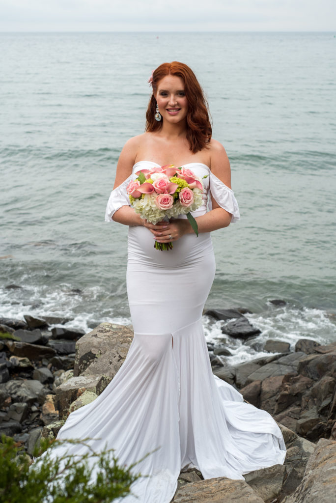bride posing on rocks in front of ocean at York Harbor Inn elopement 