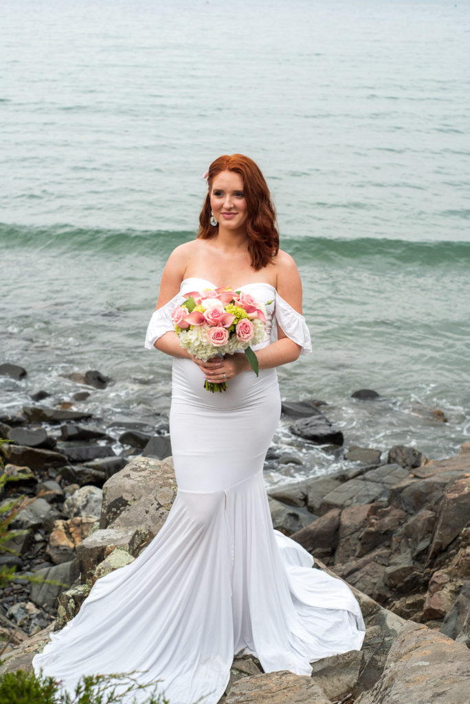 bride posing on rocks in front of ocean at York Harbor Inn elopement 