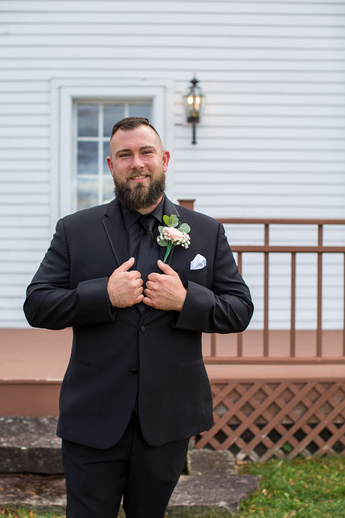 Groom holding his jacket and smiling