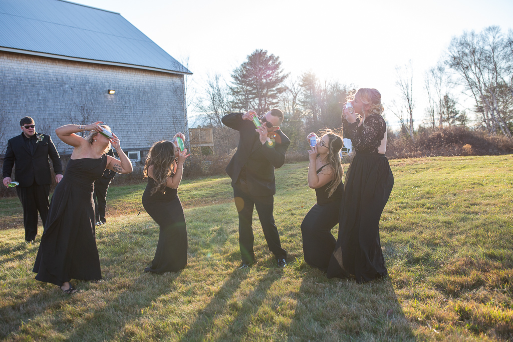 groom shotgunning a beer with the bridesmaids