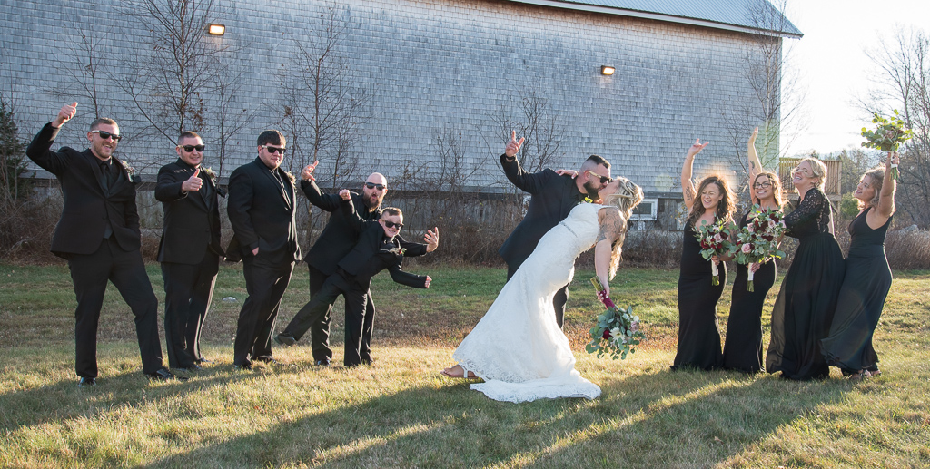 groom fist bumping while dipping his bride