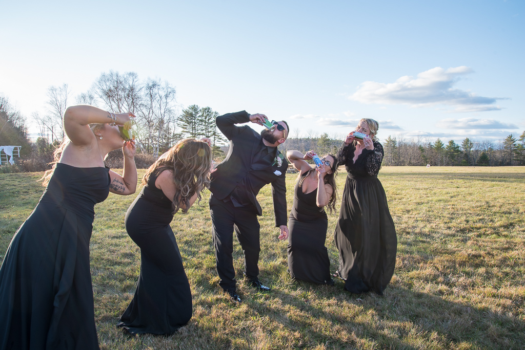 groom shotgunning beer with the bridesmaids