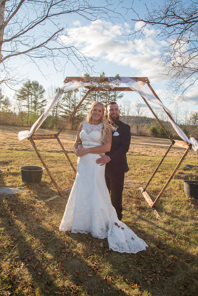 bride and groom posing in front of the hexagon arbor
