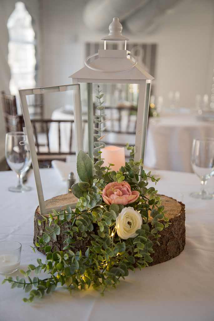 lantern centerpiece with pink flowers and a candle