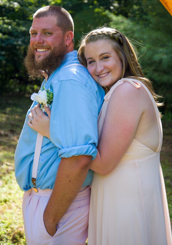 2020 backyard wedding bride hugging groom from behind