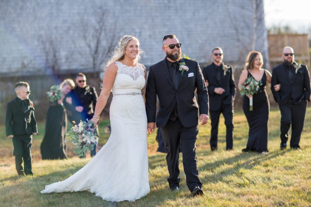 bride and groom walking holding hands with bridal party behind them - 2020 weddings