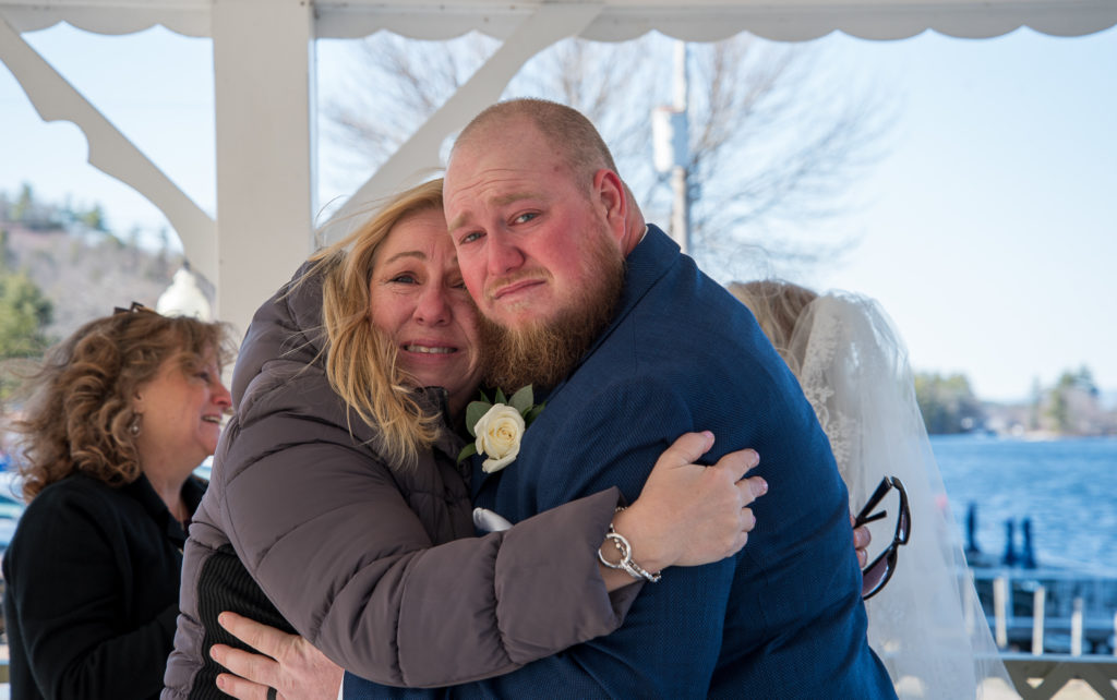 groom and his mom hugging both with tears in their eyes