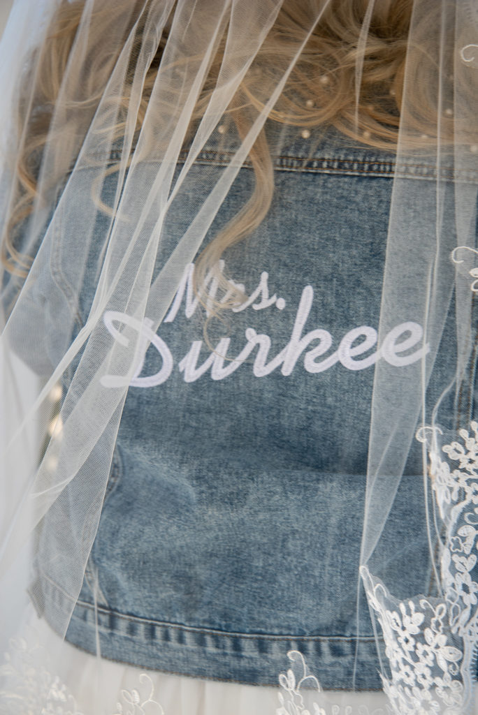 Bride's denim jacket with her new last name on the back