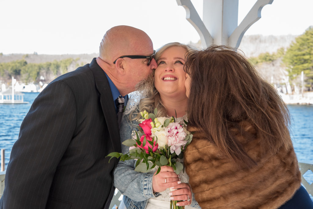 parents of the bride kissing her cheek