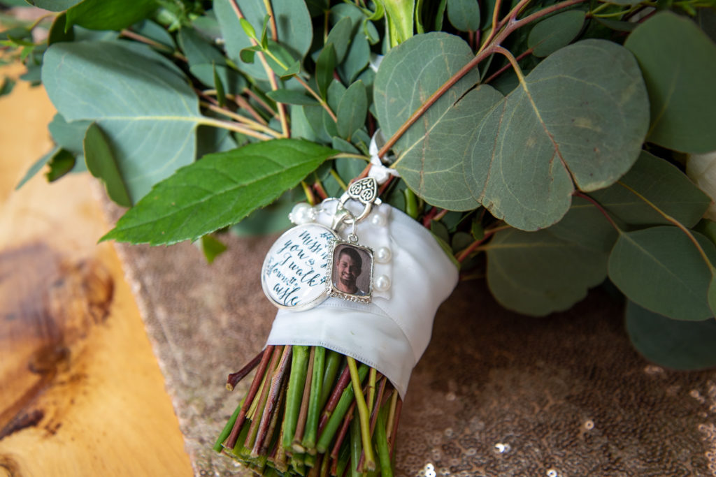 picture on a charm of deceased brother of bride on her floral bouquet