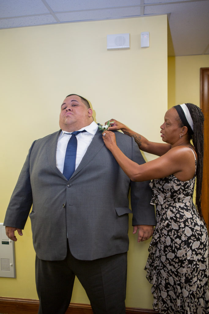 groom's aunt helping with his boutonnière