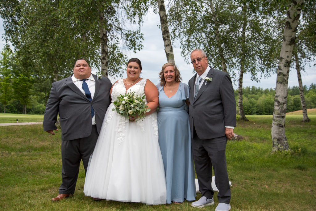 bride and groom with the bride's parents at a summer loving wedding at Stonebridge Country Club