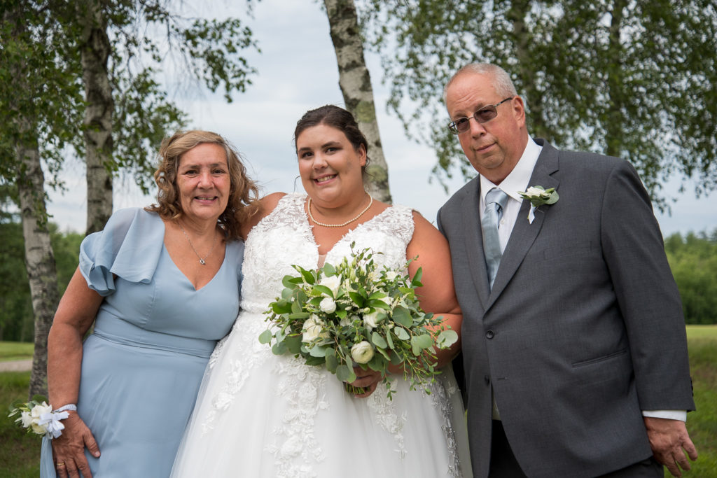 bride with the bride's parents at a summer loving wedding at Stonebridge Country Club