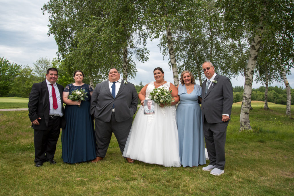 bride and groom with the bride's family at a summer loving wedding at Stonebridge Country Club