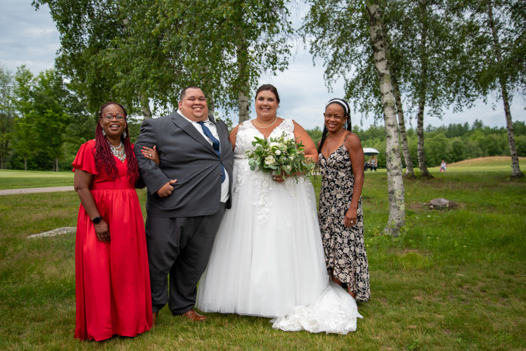 bride and groom with the groom's parents at a summer loving wedding at Stonebridge Country Club