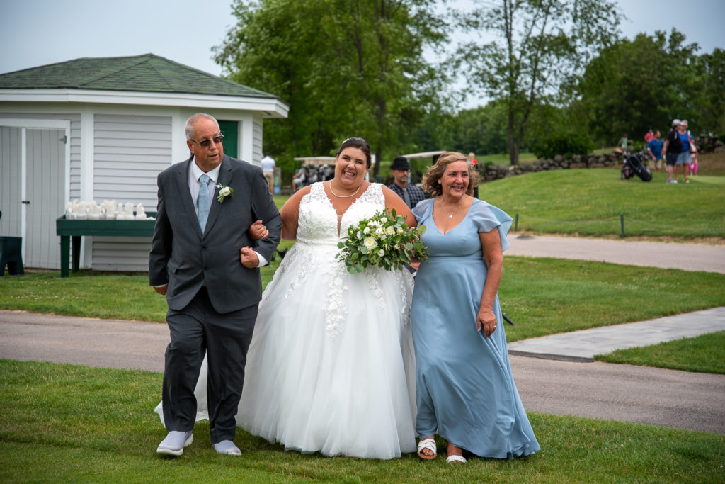 bride walking down the aisle with her parents at a summer loving wedding at Stonebridge Country Club