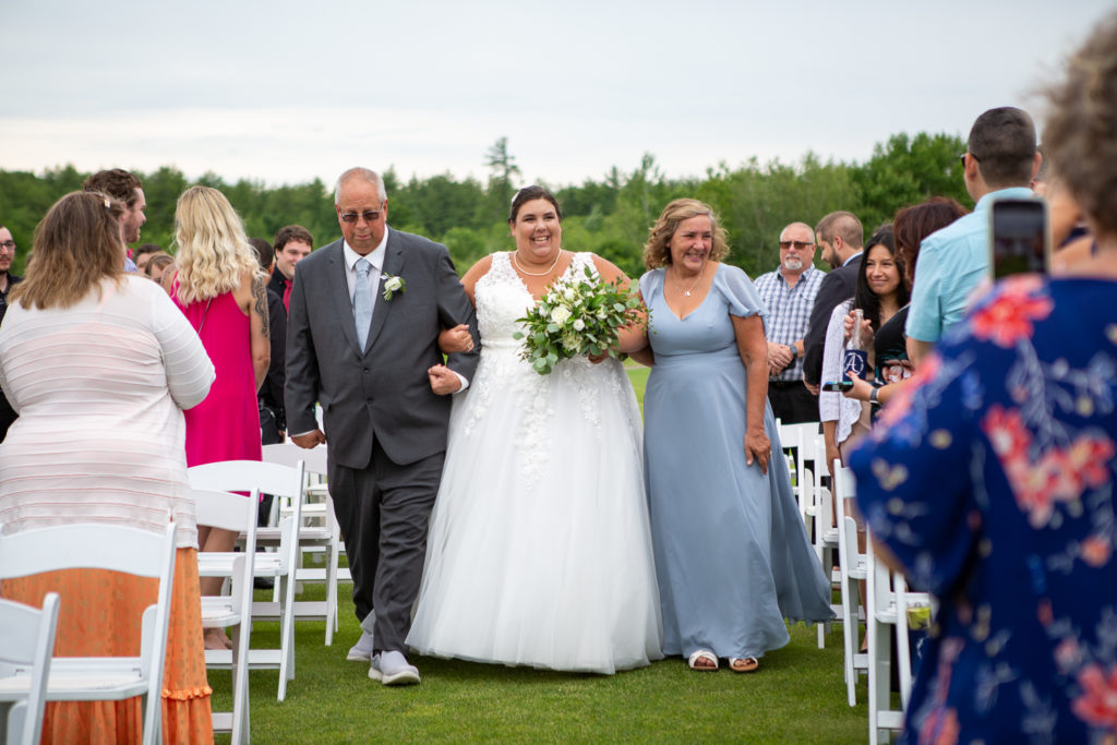 bride walking down the aisle with her parents at a summer loving wedding at Stonebridge Country Club