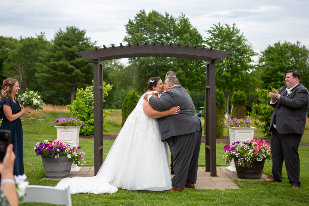 first kiss as husband and wife at summer loving wedding at Stonebridge Country Club 