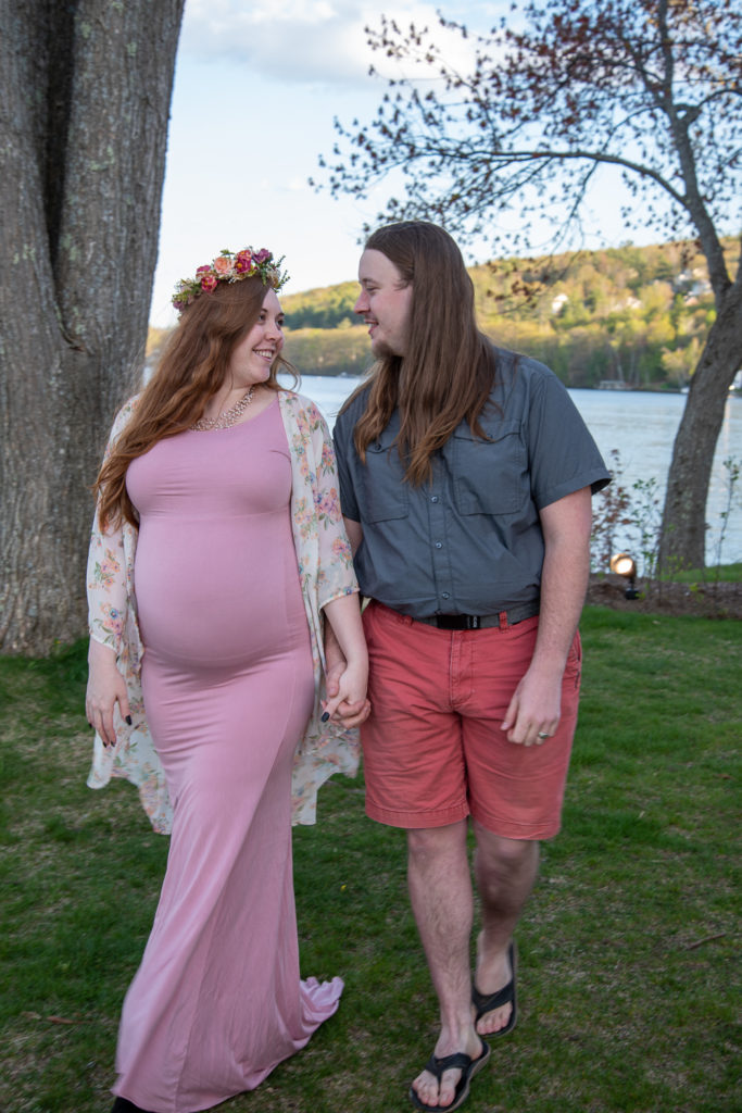 mom and dad to be holding hands at lake winni at meredith maternity session