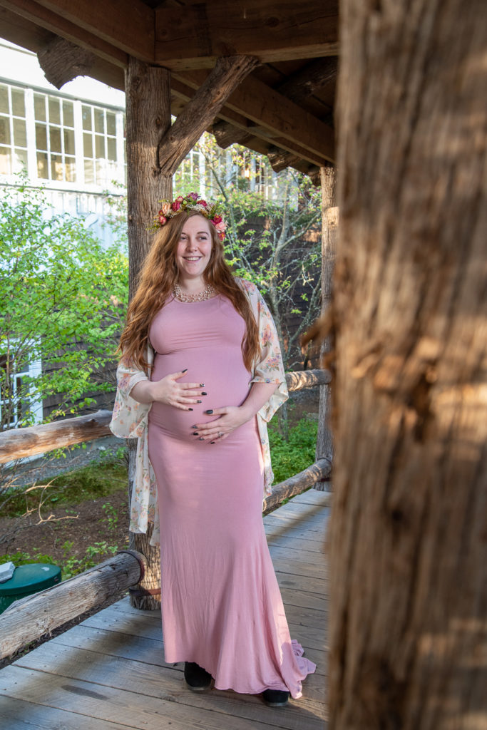 mom to be glowing while holding her belly at meredith maternity session