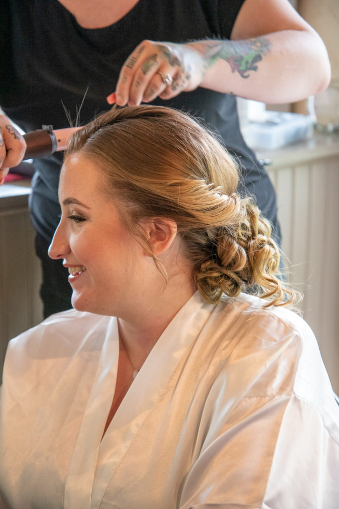 bride getting her hair done before the ceremony