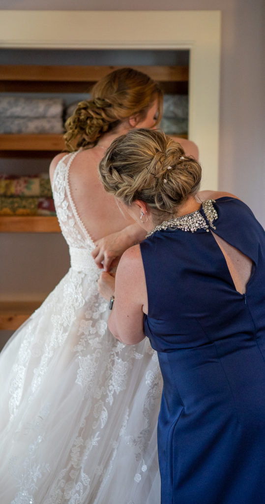 bride's mom helping button bride's dress