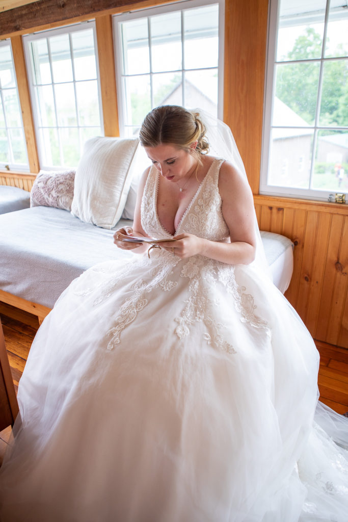 bride sitting on the bed reading the vows her husband to be wrote for her
