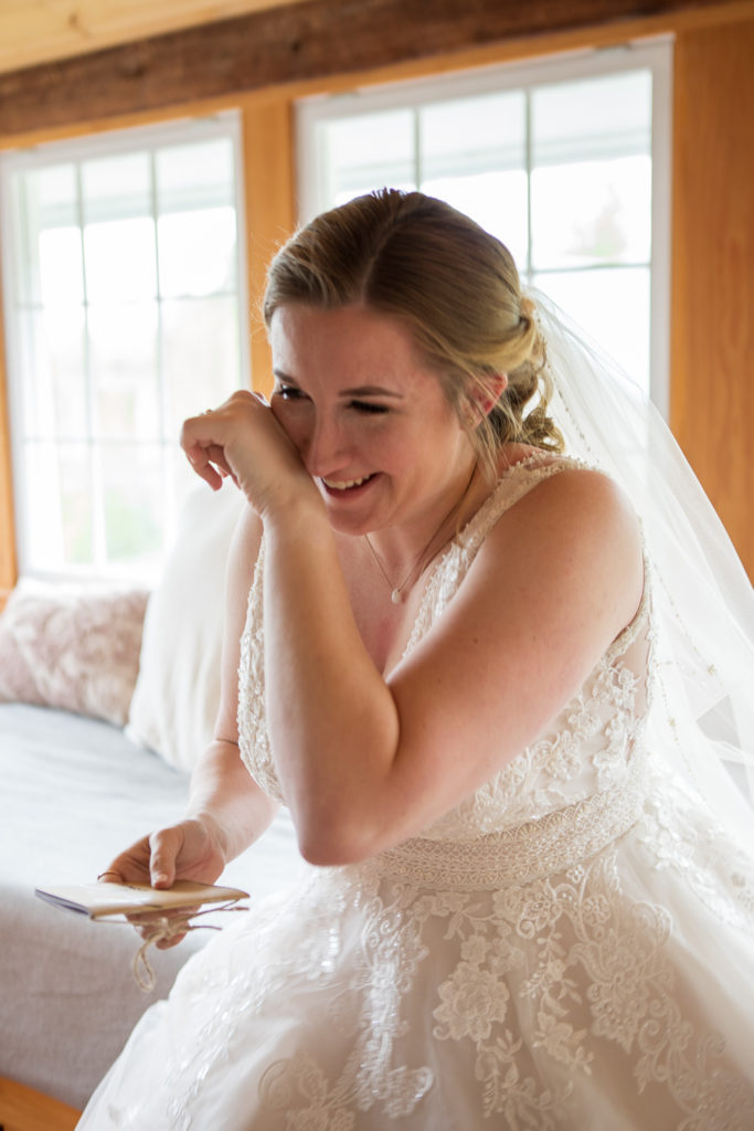 bride to be wiping a tear as she reads the vows her husband to be wrote for her