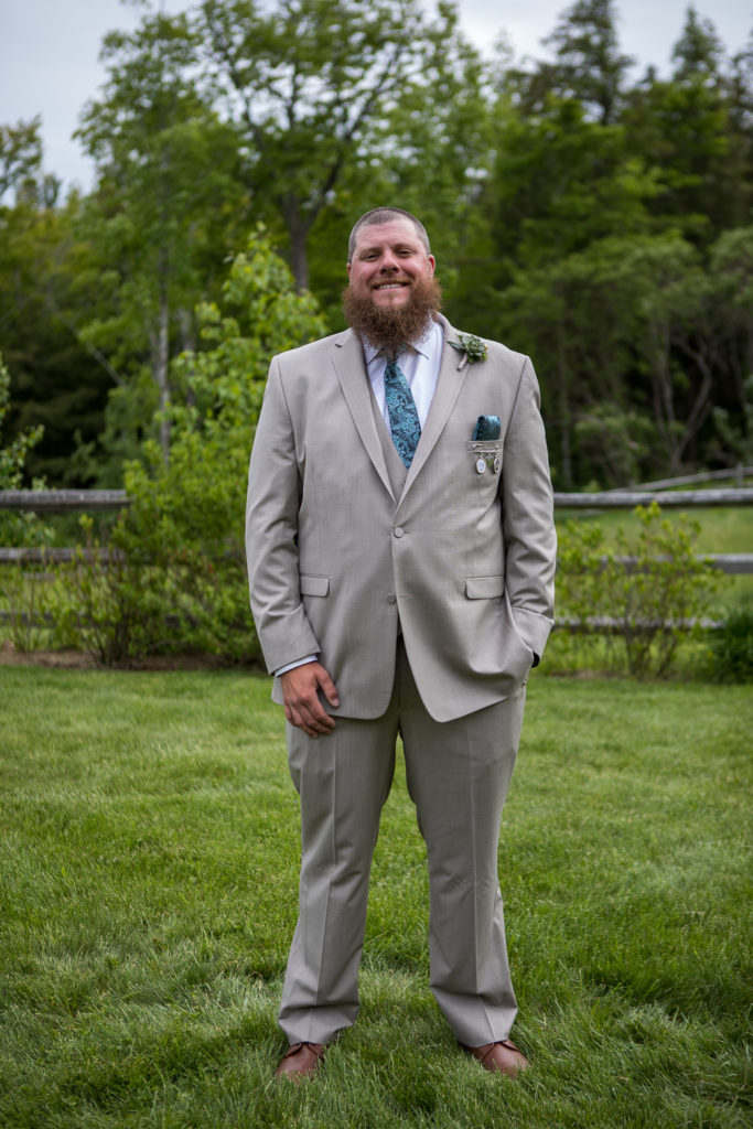 groom smiling at camera with one hand in the pocket
