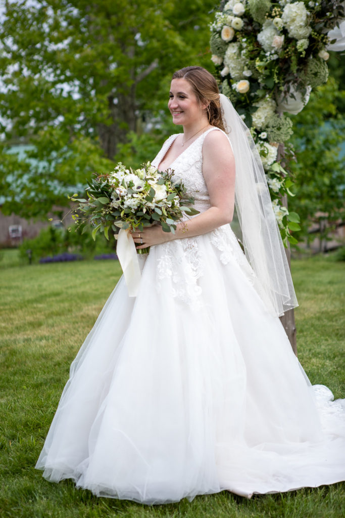 bride smiling at camera while holding her bouquet