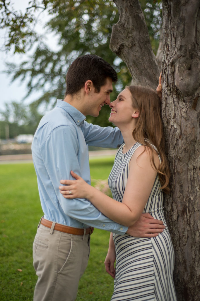 bride and groom nuzzling noses while leaning against a tree at prescott park engagement session