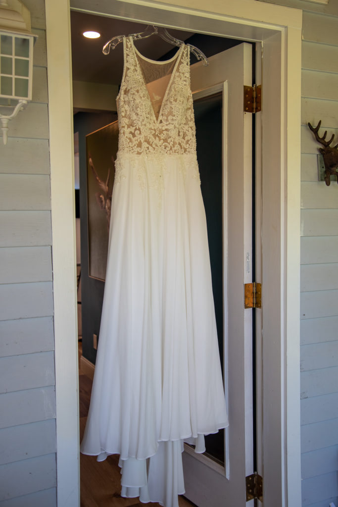 wedding dress hanging in doorway 