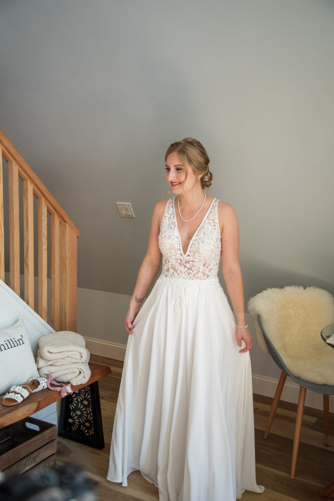 bride coming down the stairs in her wedding gown before heading to her NH summer barn wedding