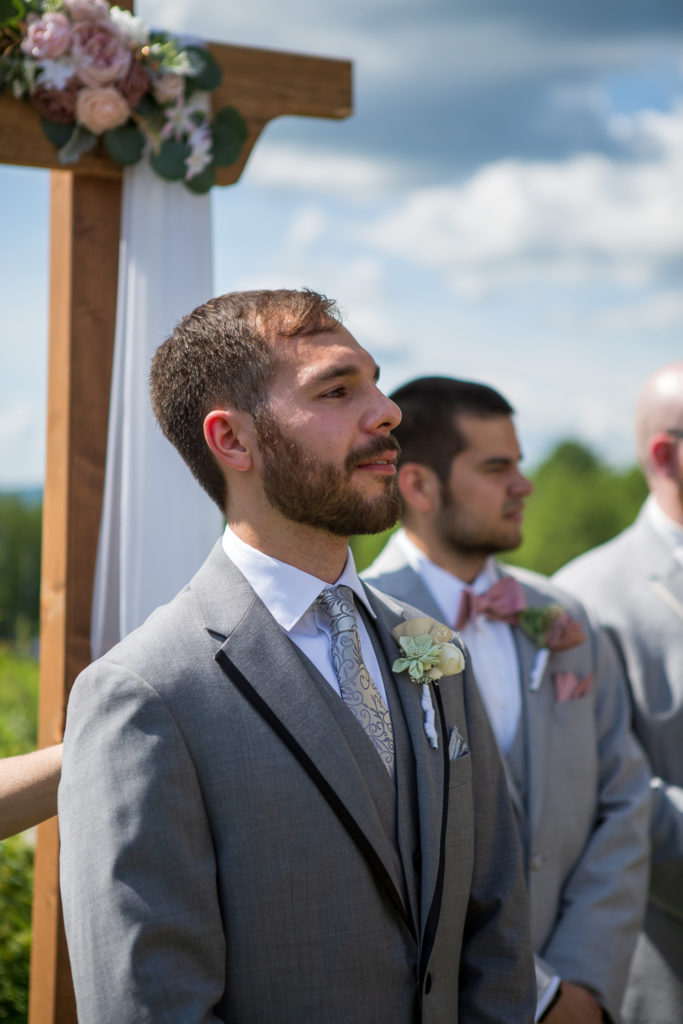 groom watching his bride walk down the aisle at NH summer barn wedding